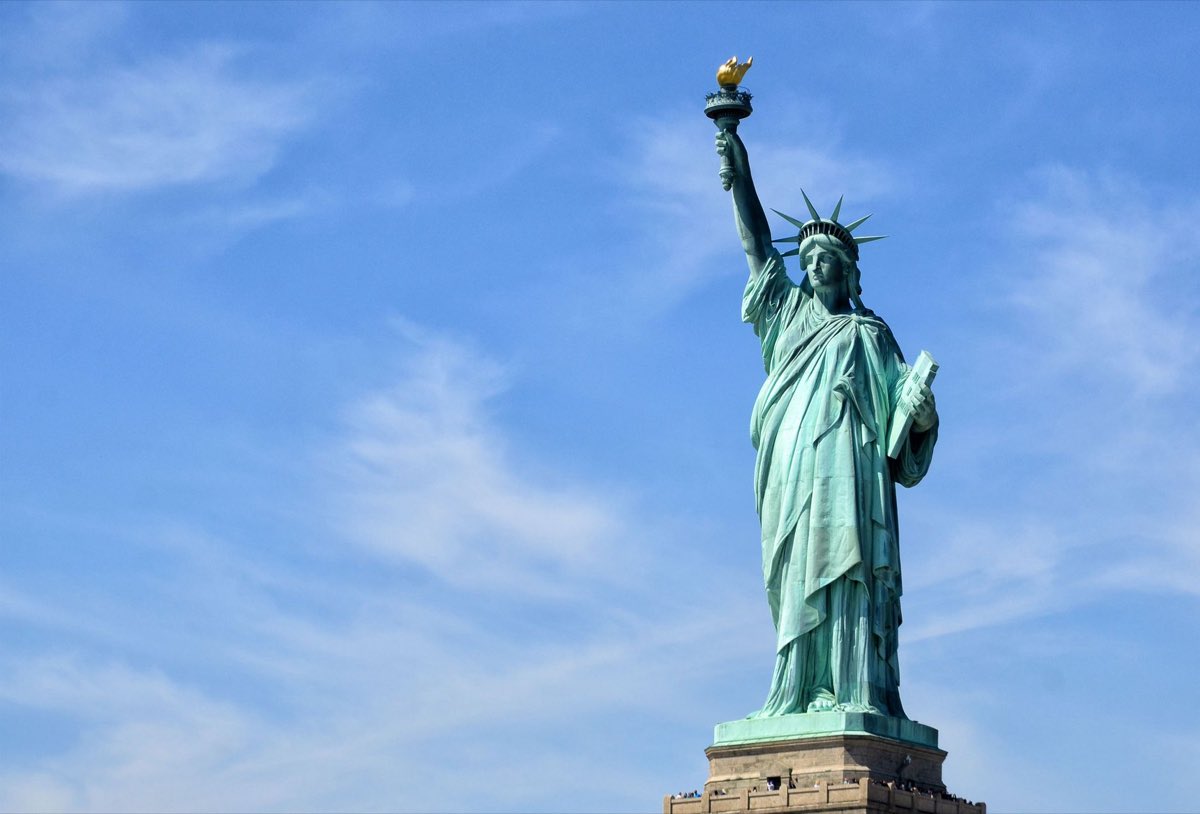 The Statue of Liberty against a blue sky, a symbol of immigrating to the United States